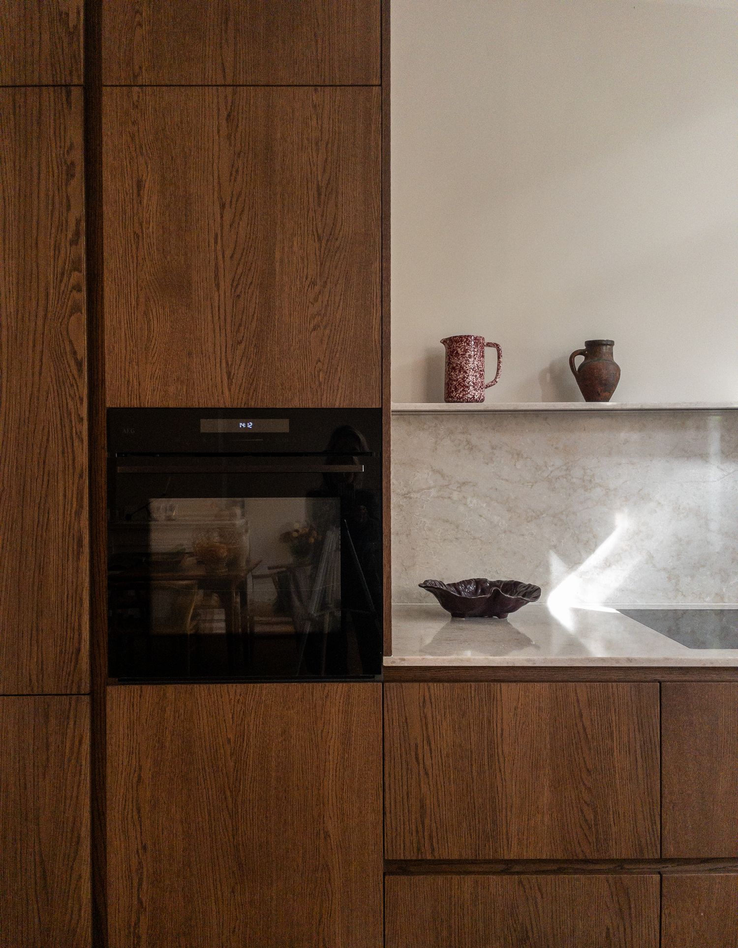 Ingebouwde oven met marmeren plank en aardewerken kannen in een keuken in Den Haag